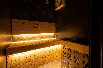 温かみのあるLED間接照明が特徴的なモダンなサウナ室の内部
