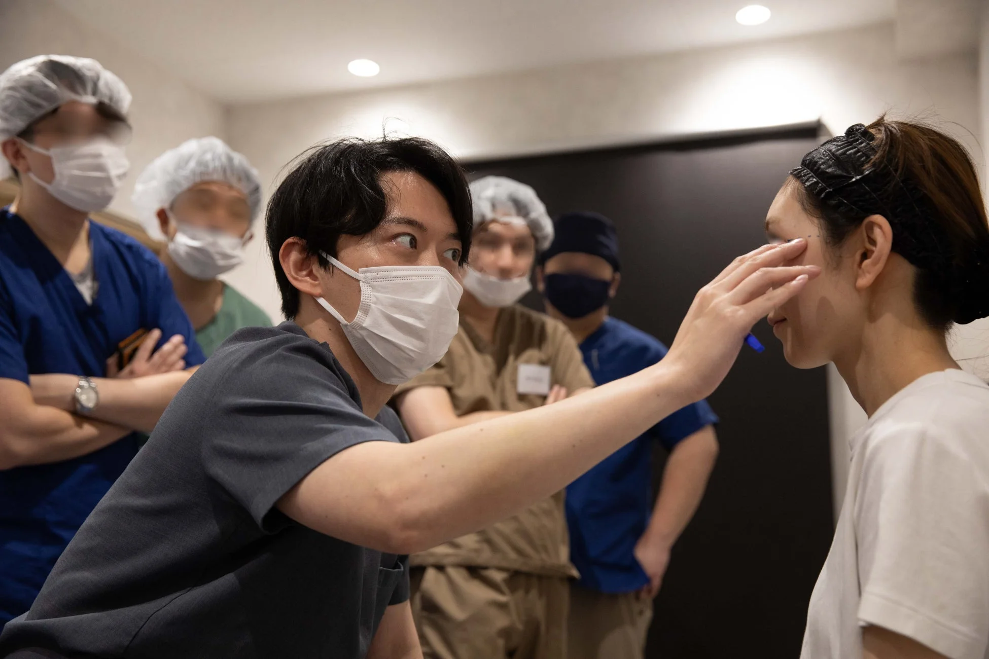 医療従事者が女性患者の顔を診察している様子
