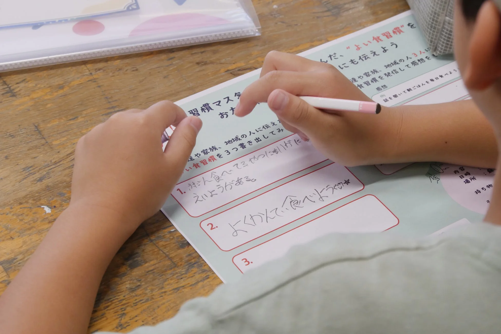 よい食習慣をテーマにしたワークシートに記入する子供