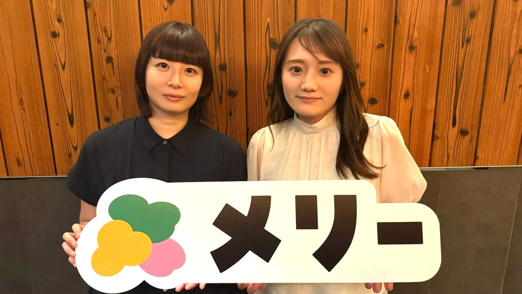 メリーのサインボードを持つ女性二人