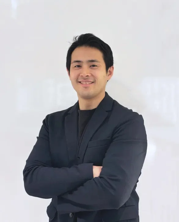 紺色のジャケットを着用し腕を組む日本人男性のポートレート