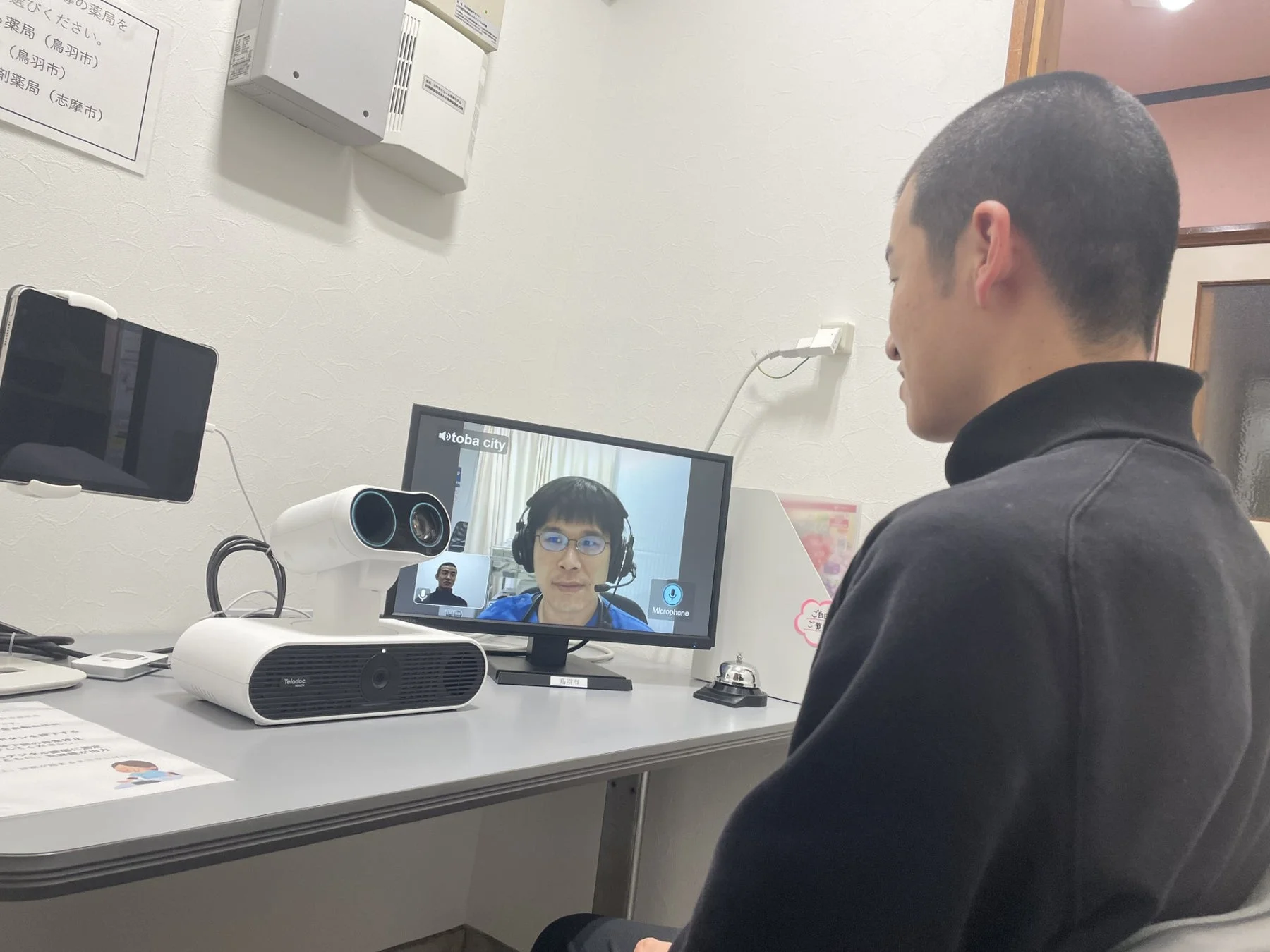 男性がモニター越しに医師とオンライン診療を行っている様子